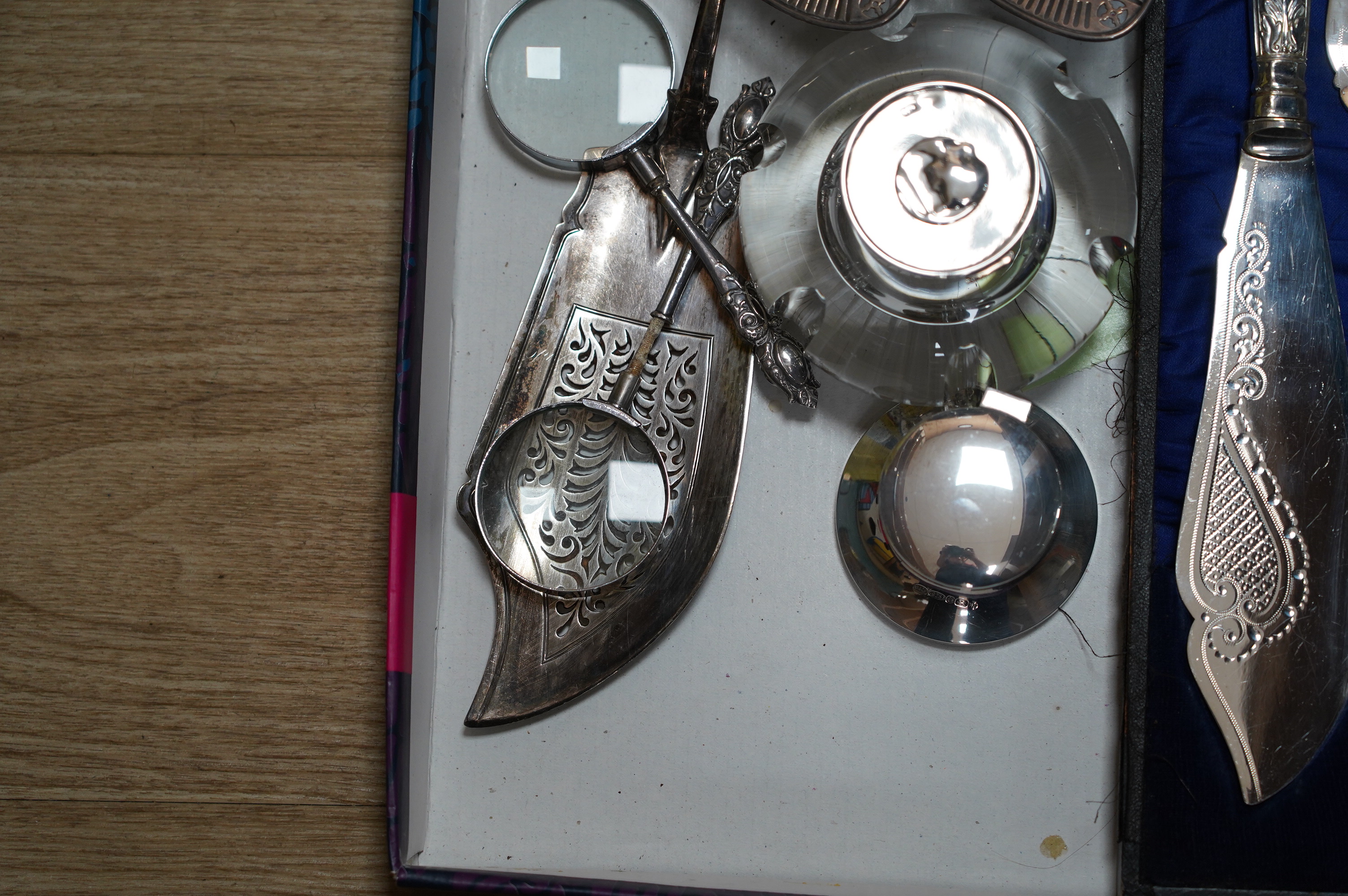 Sundry silver items including two inkwells, a William IV fiddle pattern fish slice, a pair of bonbon dishes and two handled magnifying glasses (one a.f.), together with a cased pair of plated fish servers. Condition - po